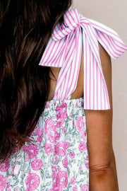 Floral mini dress with pink and white striped tie shoulders and a pink floral print skirt.