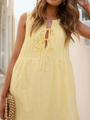 Yellow tie-front mini dress with pintuck detail and a keyhole neckline.