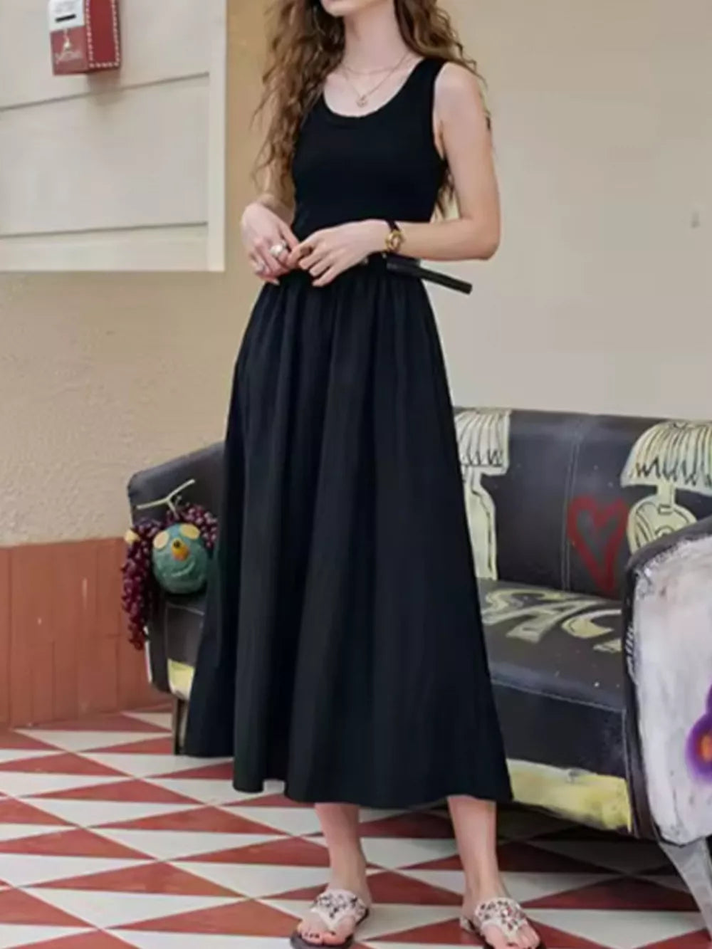 Black midi dress with fitted tank top and flowing skirt, belted waist