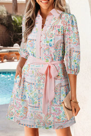 Floral patchwork mini dress with 3/4 sleeves, button-down front, and pink belt.