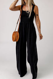 Black smocked square neck wide leg jumpsuit with adjustable straps.