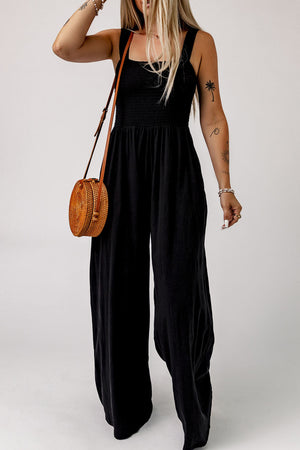 Black smocked square neck wide leg jumpsuit with adjustable straps.