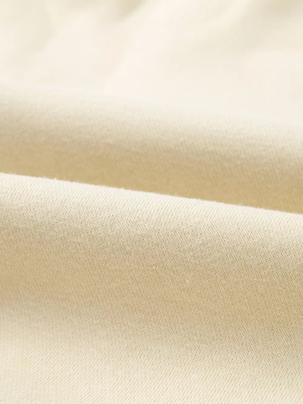 Beige cotton joggers with a soft, textured knit fabric detail.