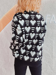 Black acrylic knit jumper with all-over white geometric heart pattern.