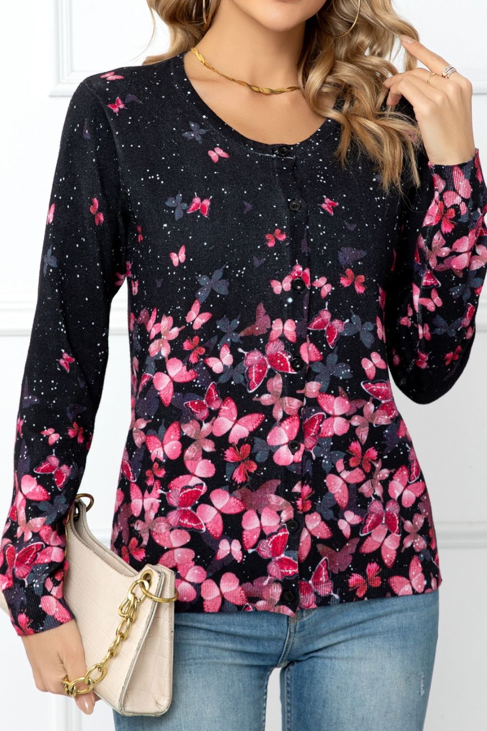 Black crewneck cardigan with allover pink butterfly print and button front.