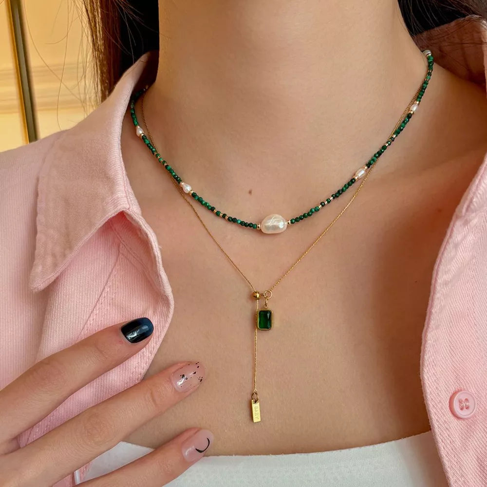 Elegant freshwater pearl and malachite necklace with gold chain and emerald pendant.