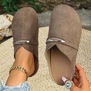 Brown slip-on flats with round toe and decorative buckle detail.