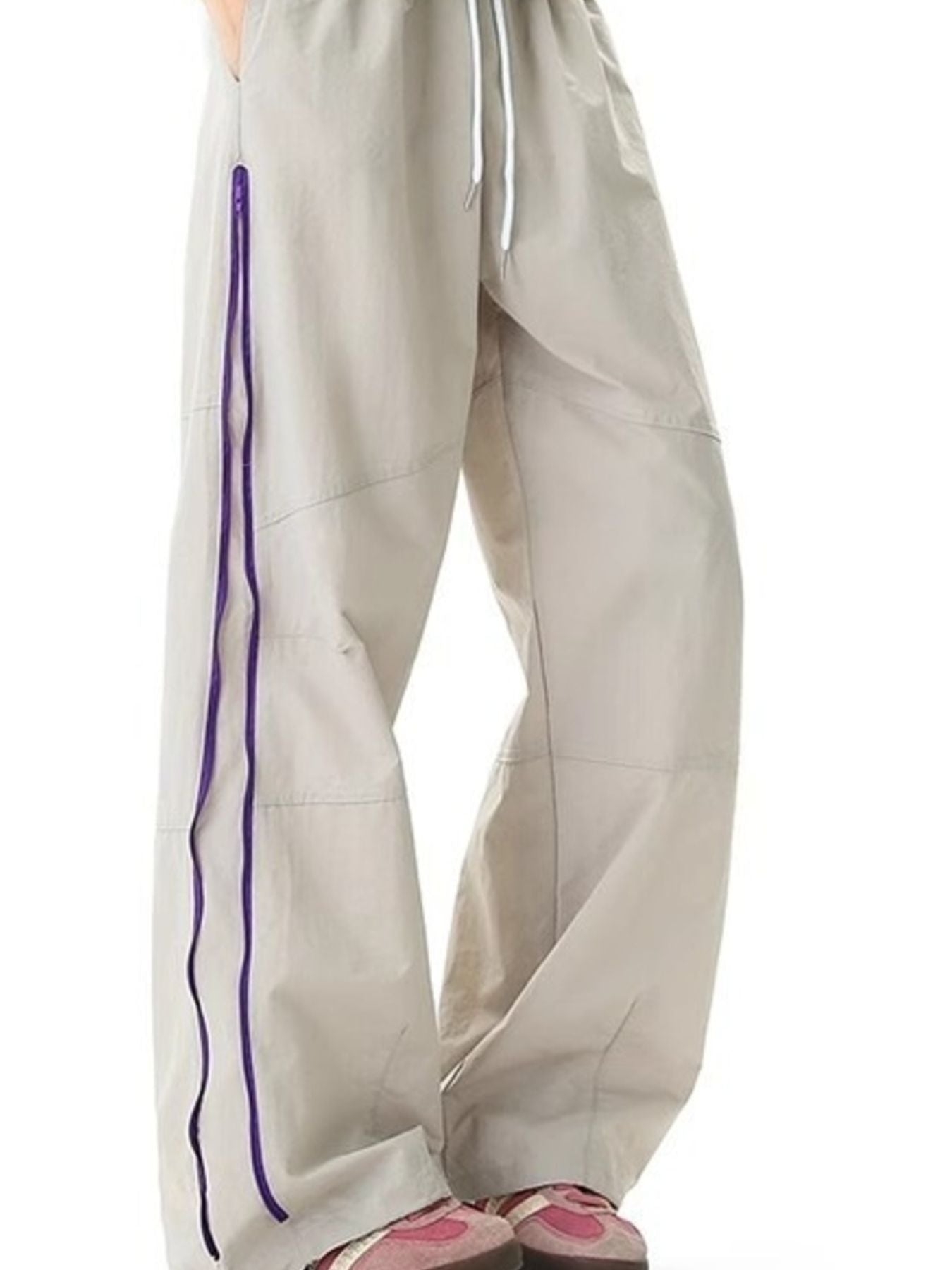 Men's beige loose-fit casual sweatpants with purple zipper detail and drawstring waist.