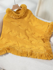 Gold cable knit poncho with faux fur trim and fringe detail.