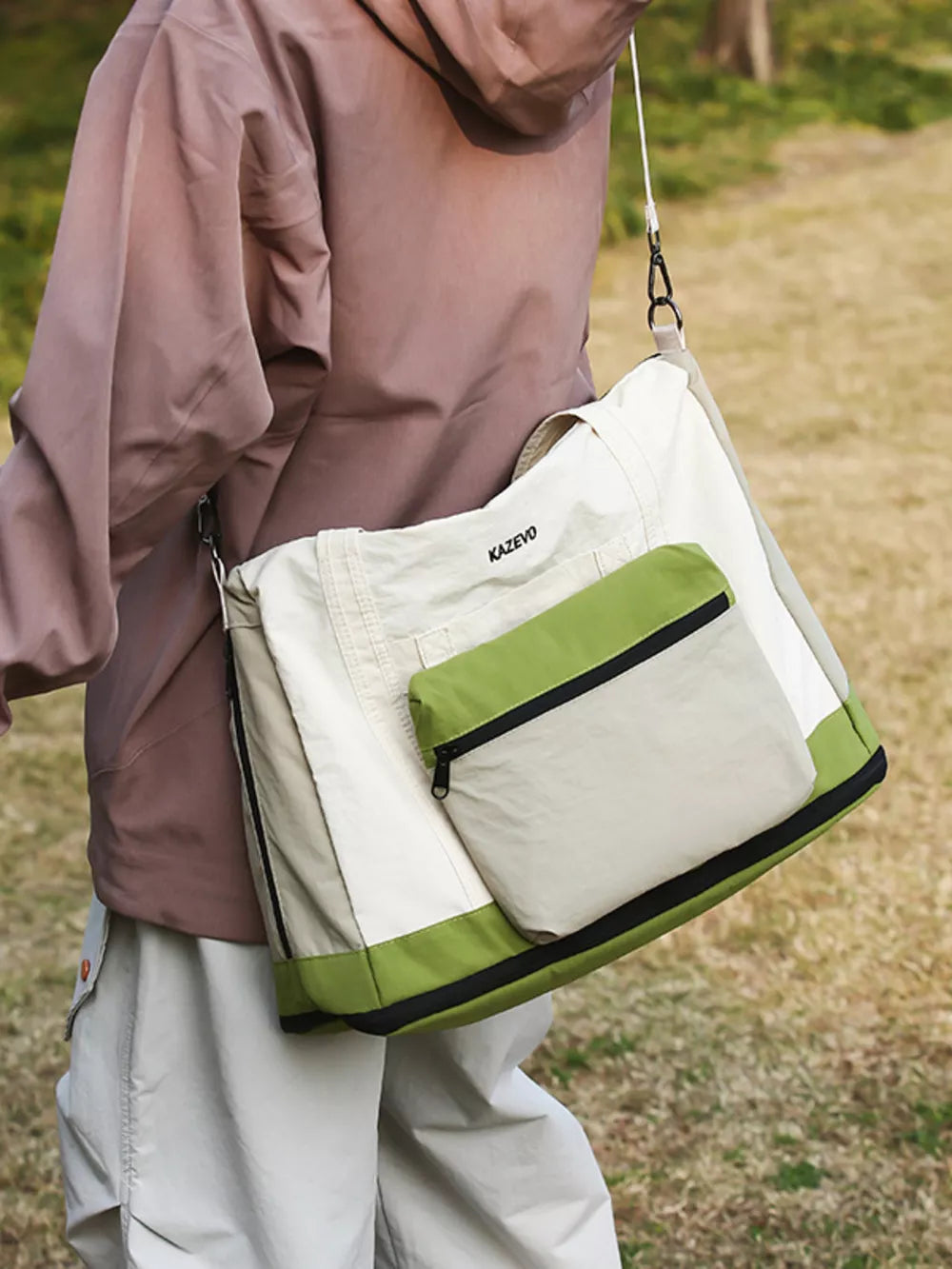 Chic nylon travel bag in beige and green with zip pocket and adjustable strap.