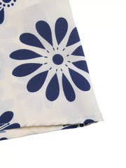 Maxi dress with navy blue floral print on white fabric, featuring cutout waist detail.