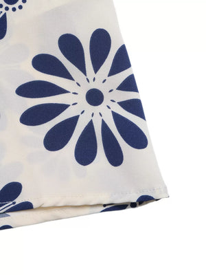 Maxi dress with navy blue floral print on white fabric, featuring cutout waist detail.