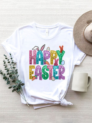 White t-shirt with glittery "Happy Easter" graphic featuring bunny ears, carrots, and eggs.