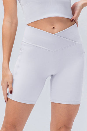 White ribbed bike shorts with a cross-waist detail and side pockets.