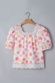 Blouse with polka dot print, square neck, puff sleeves, and lace trim.