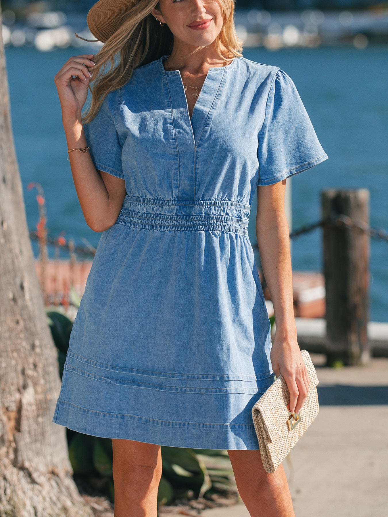 Chic denim dress with V-neck, short sleeves, elastic waist, and tiered hem.