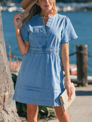 Chic denim dress with V-neck, short sleeves, elastic waist, and tiered hem.