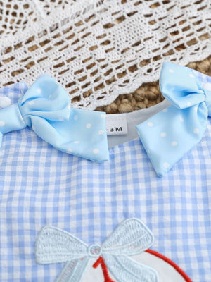 Baby blue gingham one-piece with white polka dot bows and baseball embroidery.