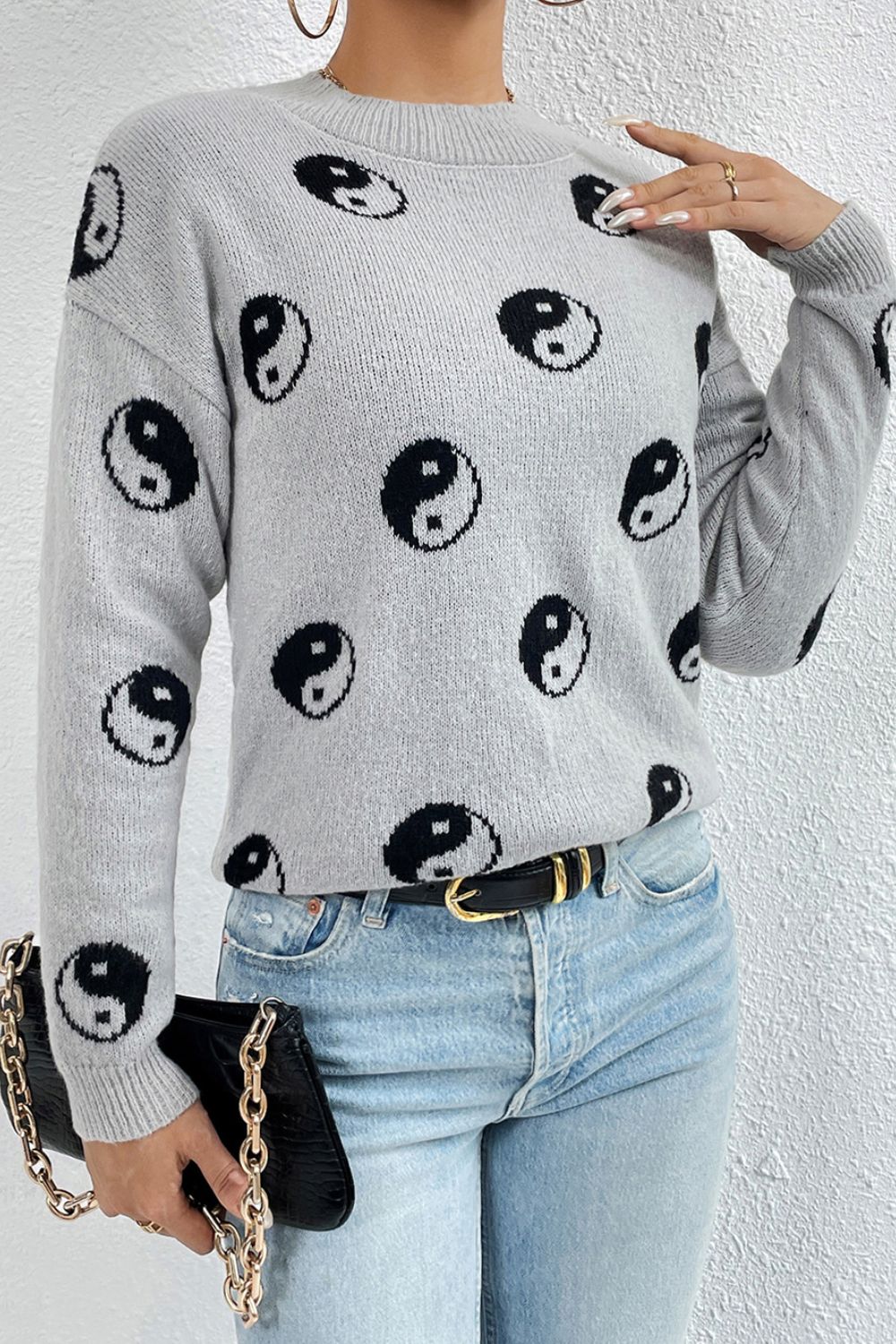 Light gray acrylic knit sweater with allover black yin yang pattern and mock neck.