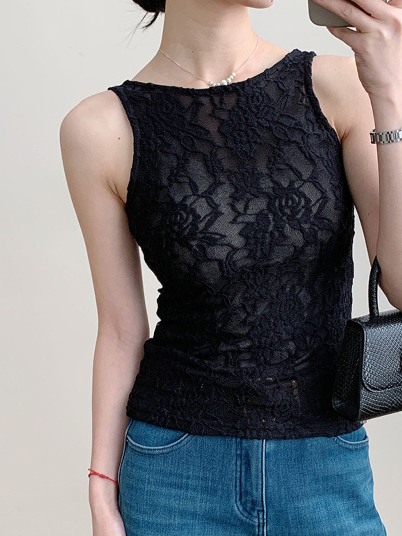 Black lace tank top with floral pattern and sheer detail.