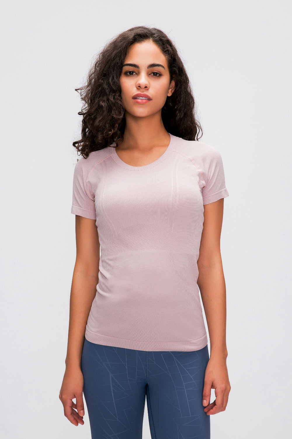 Blush pink seamless activewear tee with short sleeves and subtle textured details.