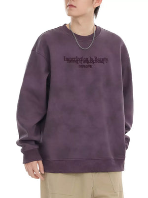 Purple oversized sweatshirt with embroidered text detail and crew neck.