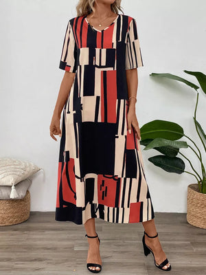 Geometric V-neck midi dress in dark blue, red, and cream abstract print.
