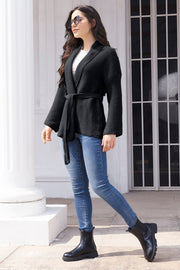 Black waffle knit belted cardigan with shawl collar and long sleeves.