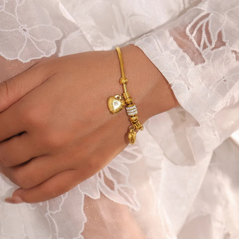 Gold charm bracelet with heart pendant and crystal beads.