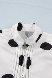 White polka dot dress with collared neckline and button-down front with pintuck details.