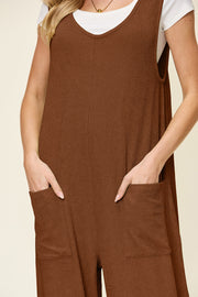 Caramel ribbed knit tie-strap jumpsuit with V-neck and side pockets.