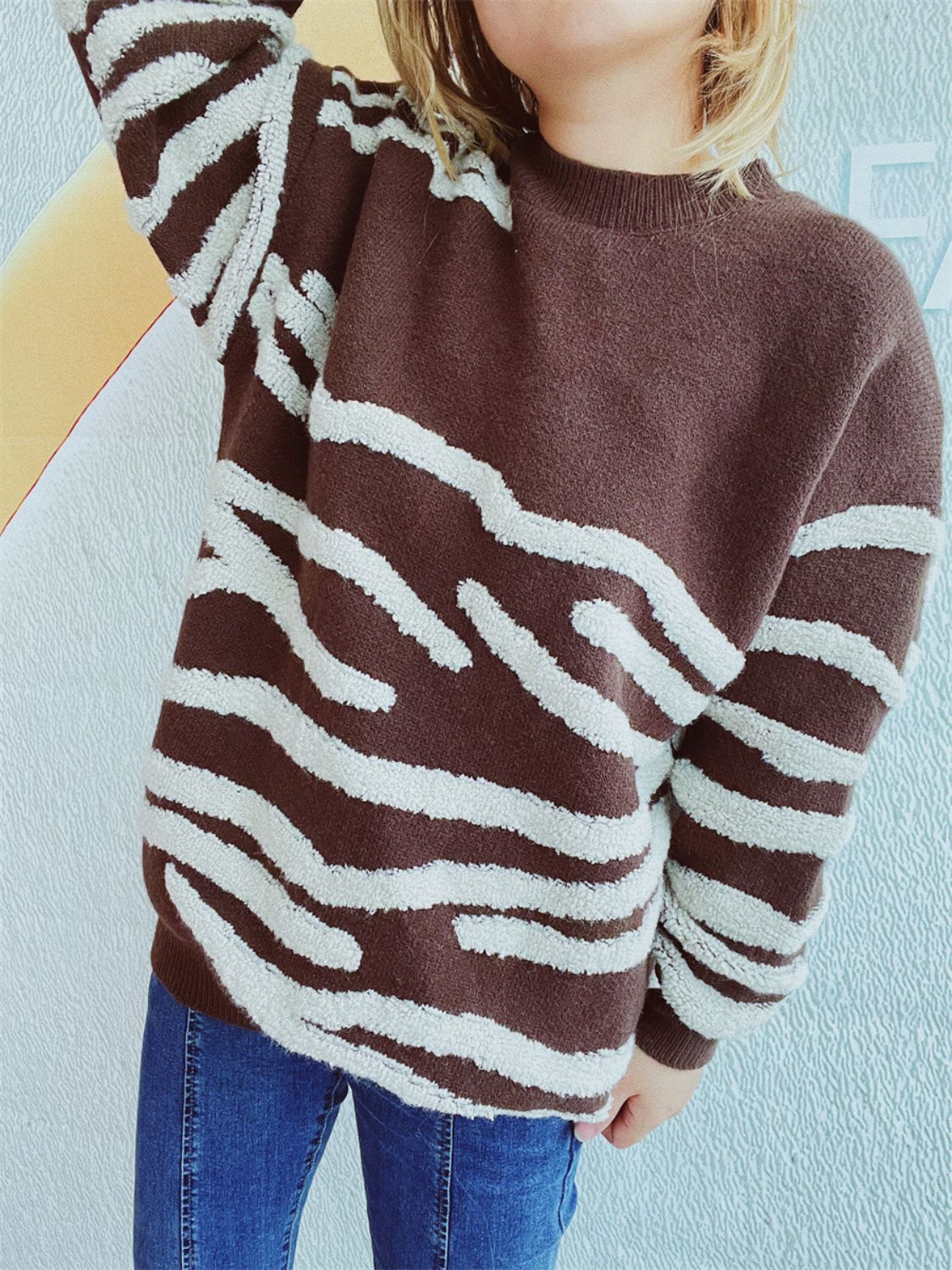 Brown acrylic crewneck sweater with textured white stripes.