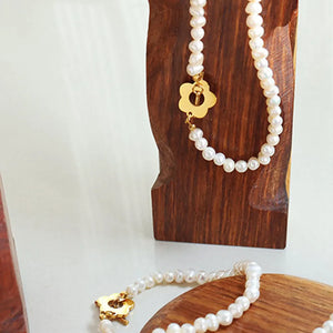 Pearl bracelet with gold flower clasp detail