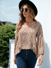 Beige dotted print blouse with balloon sleeves and V-neck.