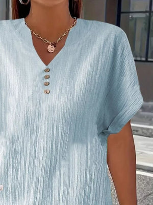 Light blue textured V-neck t-shirt with decorative buttons and short sleeves.