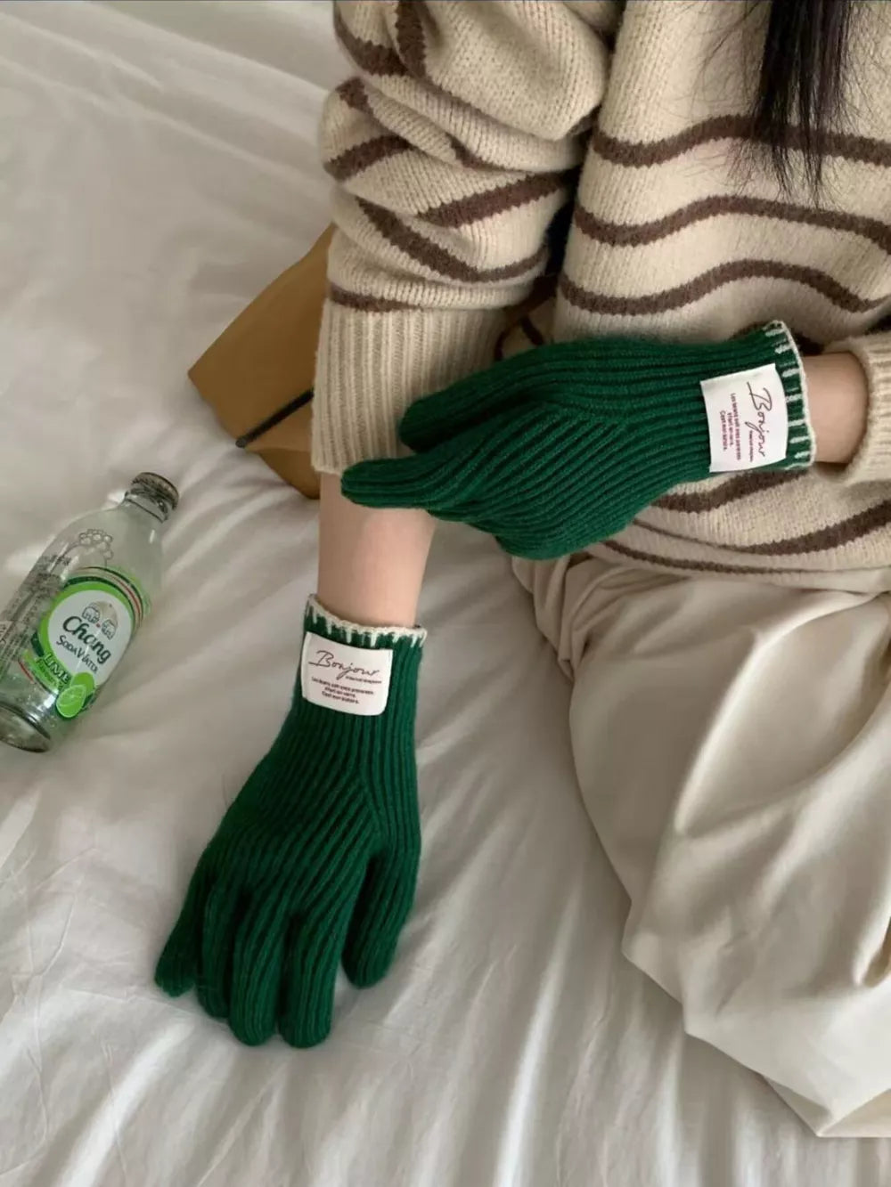 Green ribbed knit gloves with scalloped cuff and white trim detail.