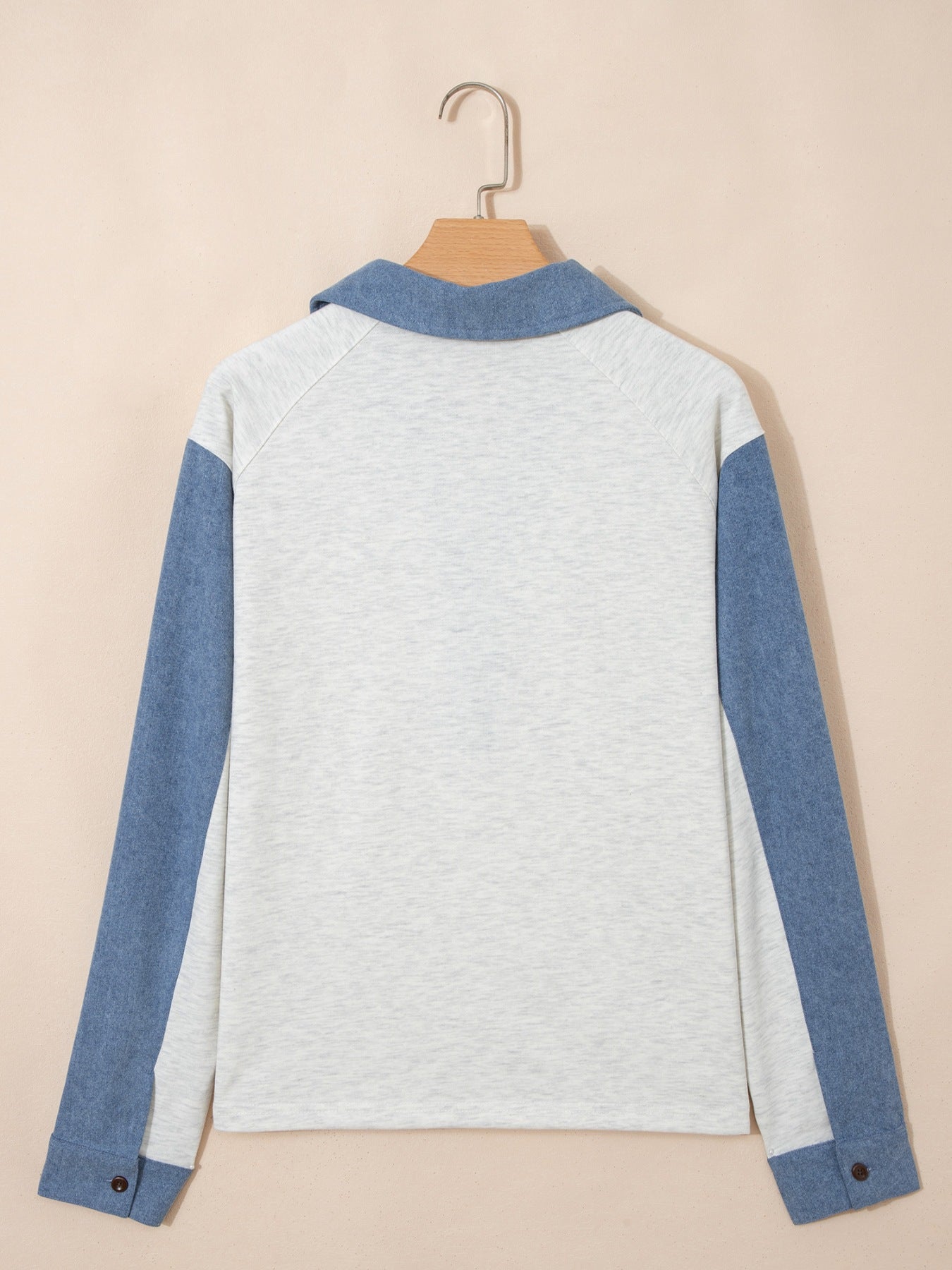 Heathered casual top with blue sleeves and button detail
