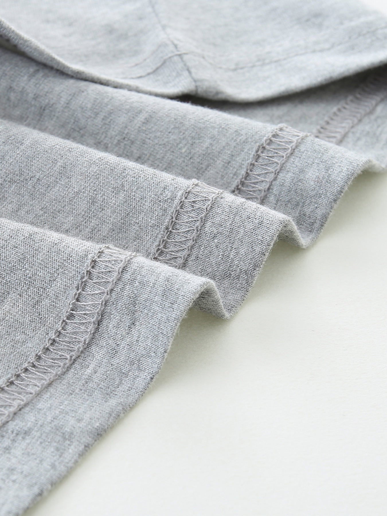 Grey cotton t-shirt detail showing hem stitching
