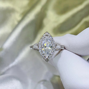 White Marquise Halo Moissanite Engagement Ring with baguette and round accent stones.