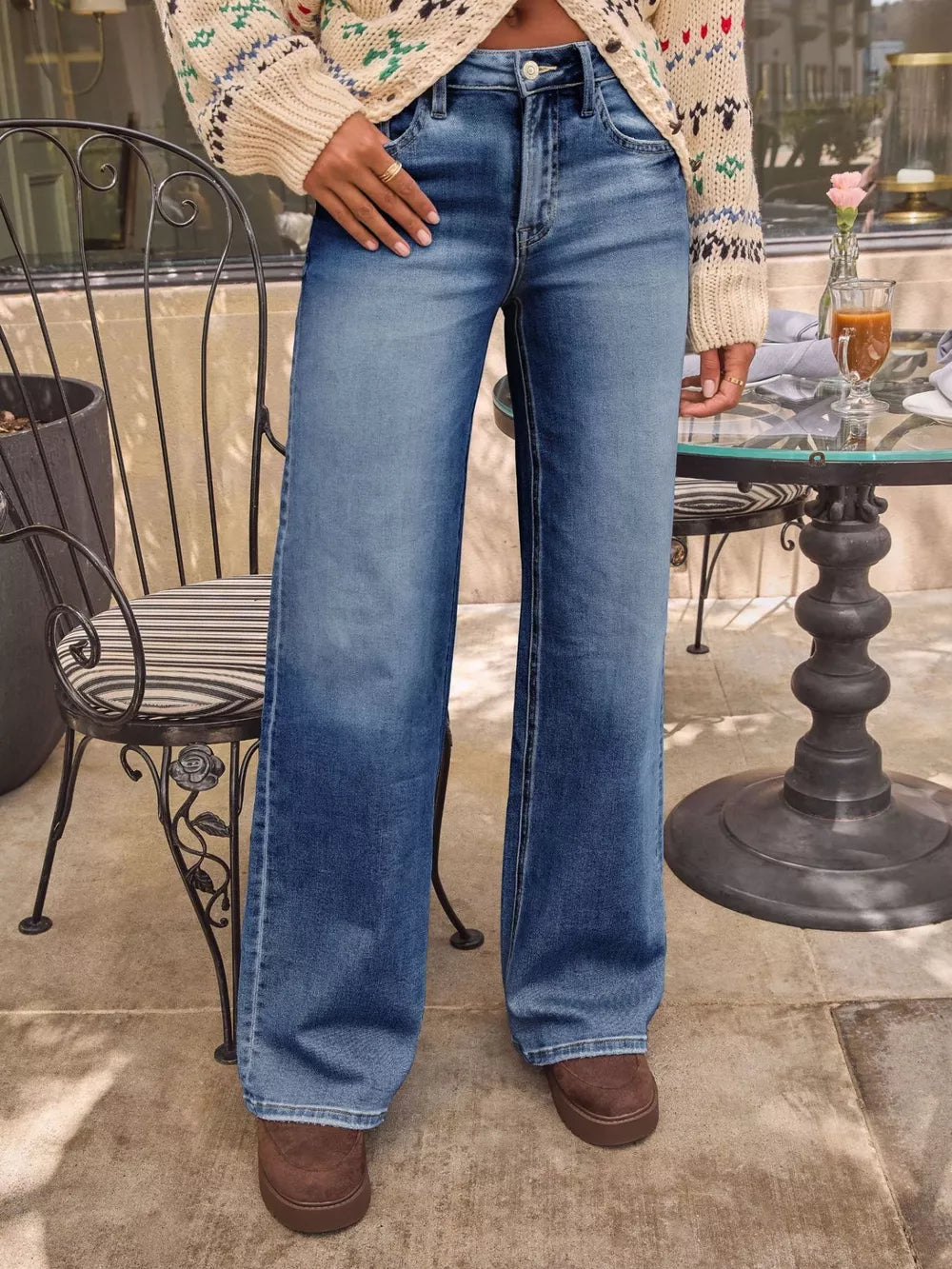 Light blue denim wide-leg jeans with a high waist and button fly, styled with a patterned sweater.