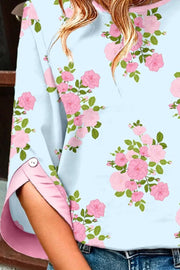 Light blue cotton shirt with pink floral print and 3/4 sleeves with pink trim and button detail.