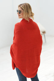 Red batwing knit cardigan with textured stitch and draped front.