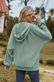 Sage textured cable knit hoodie with a hood and long sleeves.