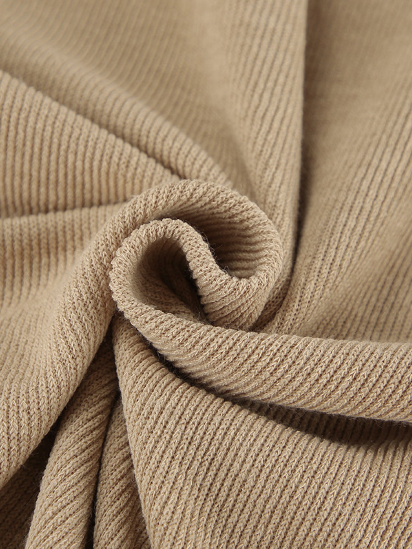 Beige ribbed knit fabric detail of a cowl-neck turtleneck and pants set.