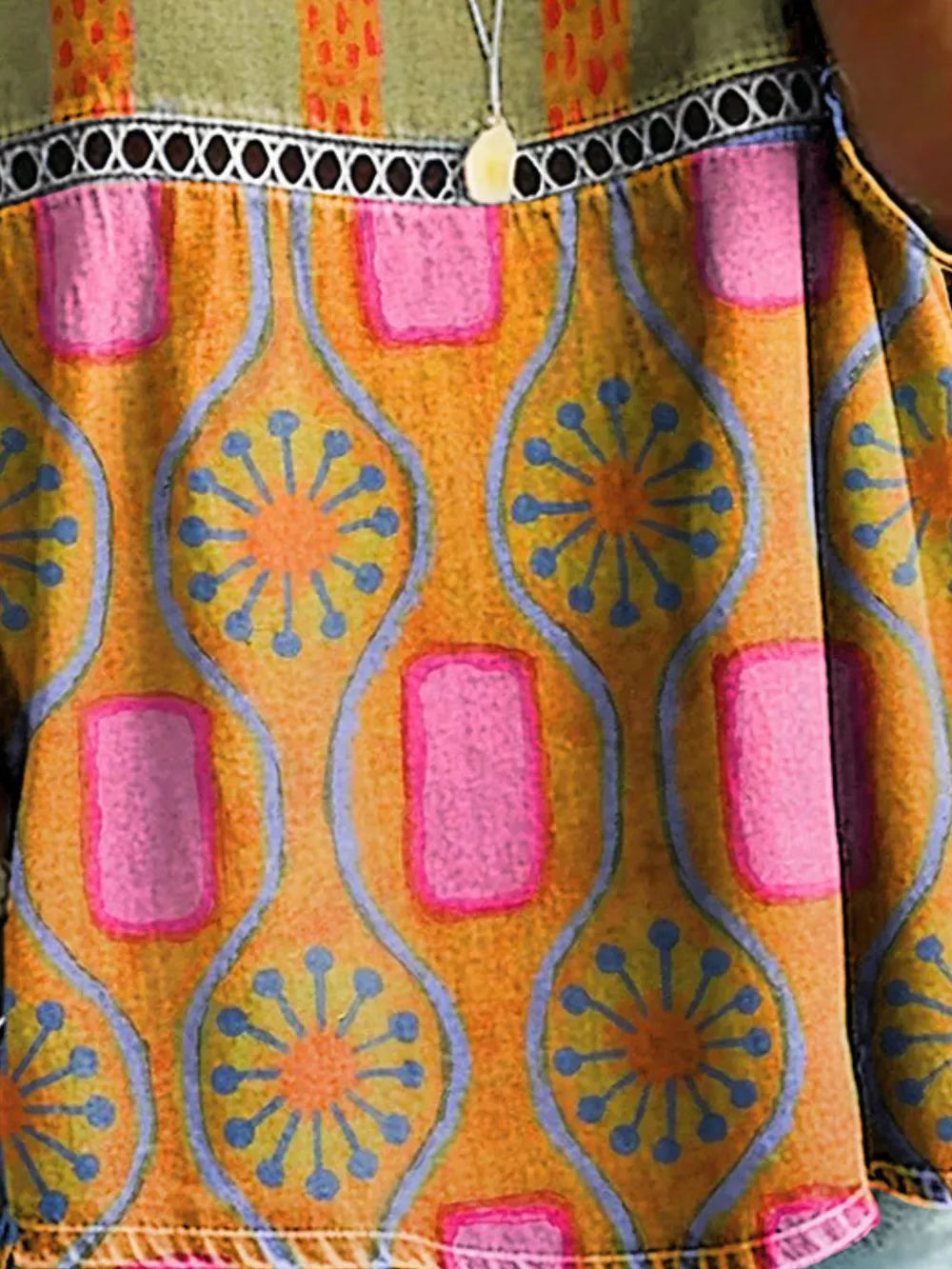 Bohemian floral openwork t-shirt in orange with pink and blue abstract print, featuring a decorative trim.