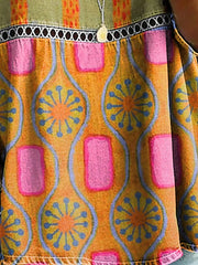 Bohemian floral openwork t-shirt in orange with pink and blue abstract print, featuring a decorative trim.