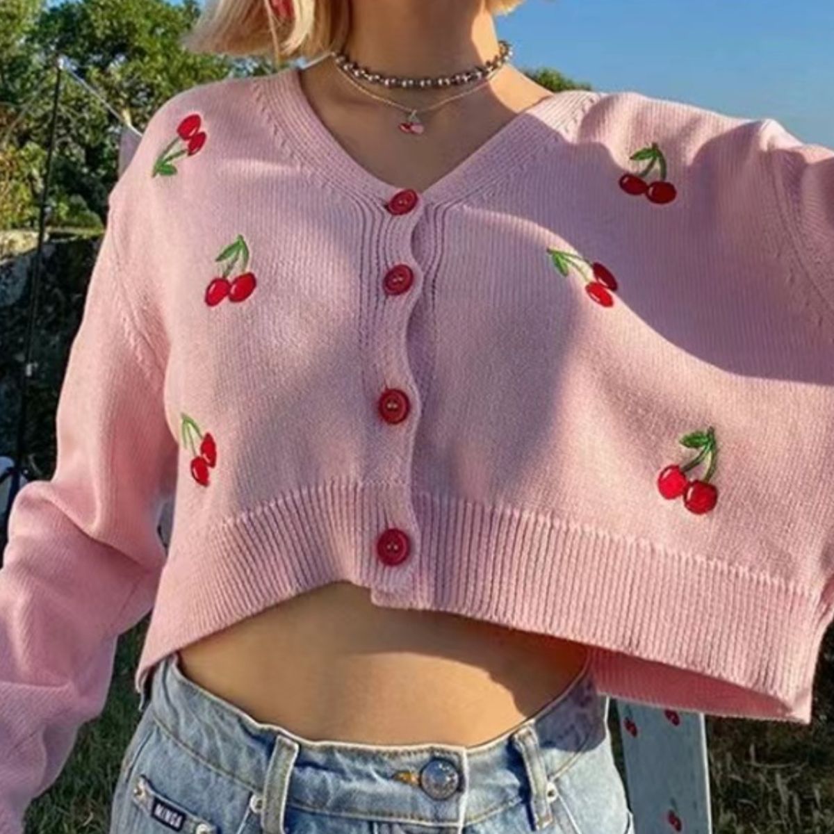 Pink cropped cardigan with cherry embroidery and button front.