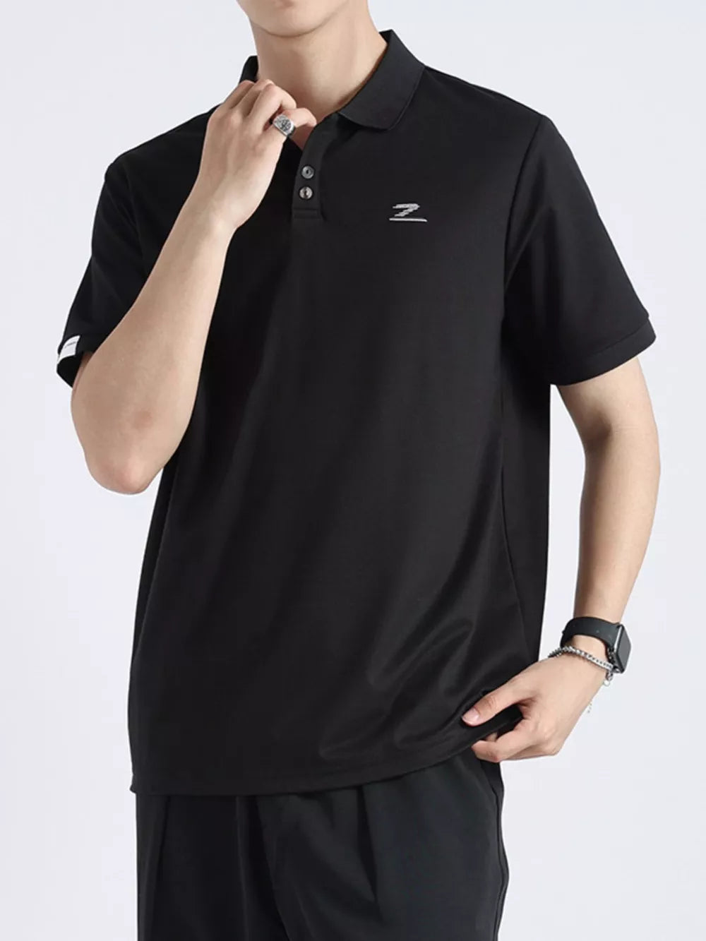Black textured casual polo shirt with button accents and a subtle logo on the chest.