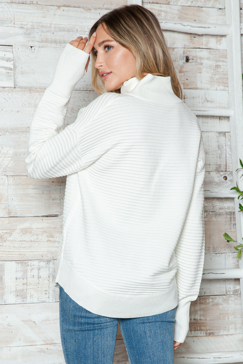White ribbed knit funnel neck sweater with long sleeves and a relaxed fit.