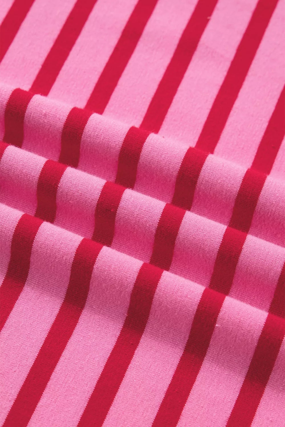 Maxi tee dress in pink with red stripes, cotton fabric, close-up view.